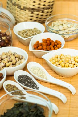 Ahşap arka planda karışık fındık ve hasır sepet çeşitleri