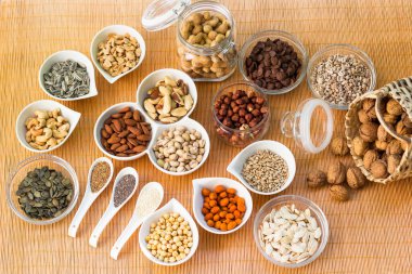 Ahşap arka planda karışık fındık ve hasır sepet çeşitleri