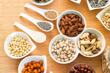 Ahşap arka planda karışık fındık ve hasır sepet çeşitleri