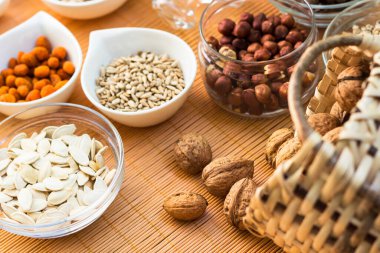 Ahşap arka planda karışık fındık ve hasır sepet çeşitleri