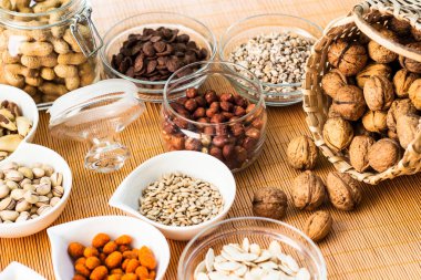 Ahşap arka planda karışık fındık ve hasır sepet çeşitleri