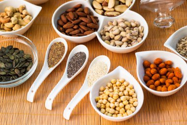 Ahşap arka planda karışık fındık ve hasır sepet çeşitleri