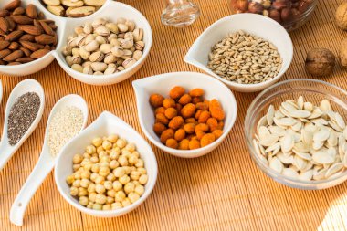 Ahşap arka planda karışık fındık ve hasır sepet çeşitleri