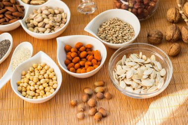 Ahşap arka planda karışık fındık ve hasır sepet çeşitleri