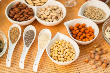 Ahşap arka planda karışık fındık ve hasır sepet çeşitleri