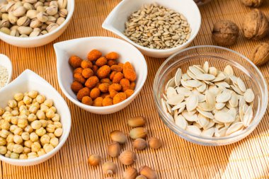 Ahşap arka planda karışık fındık ve hasır sepet çeşitleri