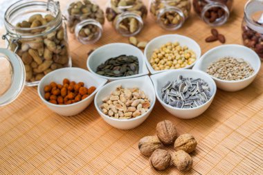 Ahşap arka planda karışık fındık ve hasır sepet çeşitleri