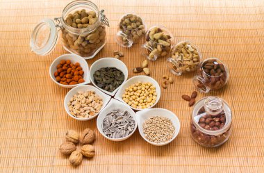 Ahşap arka planda karışık fındık ve hasır sepet çeşitleri