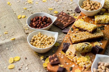 Granola çikolataları ve karışık fındıklar. Fıstıklı, çikolatalı, kurutulmuş meyveli, susamlı ve ayçiçeği tohumlu.