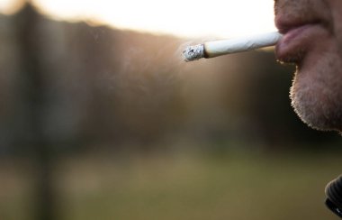 Son sınıf öğrencisi dışarıda sigara içiyor.