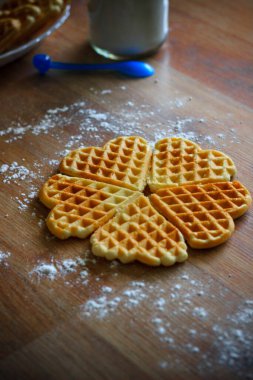 Tahta arka planda pudra şekerli gözlemeler