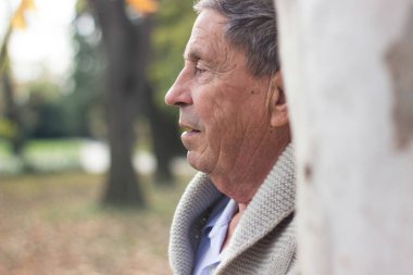 Yaşlı adam dışarıda dinleniyor ve aşağıya bakıyor. Son sınıf öğrencisinin portresi düşünceli görünüyor.