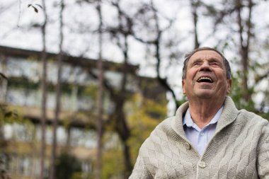 Yaşlı adam dışarıda dinleniyor ve başka tarafa bakıyor. Son sınıf öğrencisinin portresi düşünceli görünüyor.