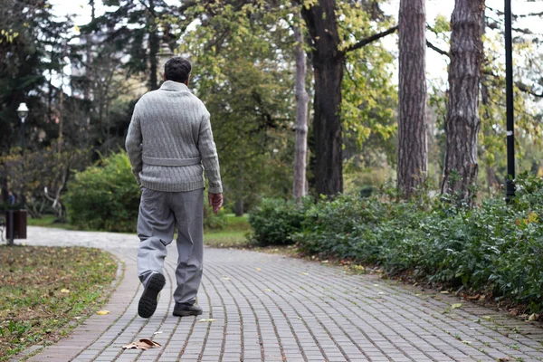 Yaşlı adam parkta yürüyor ve dinleniyor. Uzaklaşıyor, rahatlıyor, dikiz aynasından bakıyor.