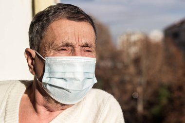 Koruyucu yüz maskesi takan yaşlı bir adamın portresi. Sağlık güvenliği kavramı