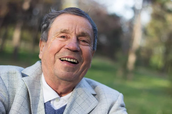 Açık havada, halka açık bir parkta gülümseyen son sınıf öğrencisinin portresi. Yaşlı adam dışarıda dinleniyor ve kameraya bakıyor. Emekliliğin tadını çıkaran yaşlı bir adamın portresi