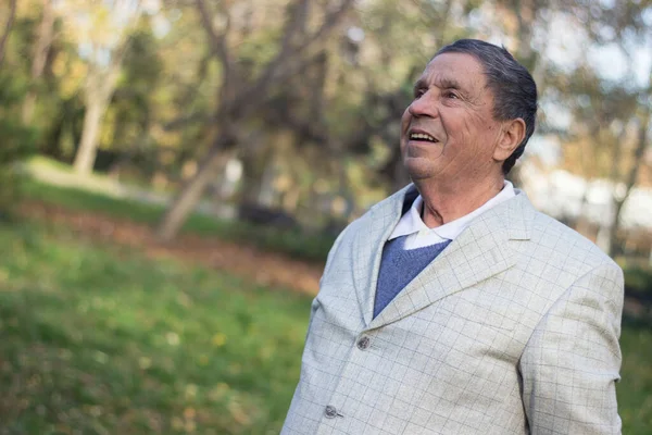 Portrait of a smiling senior man in Nature, looking away