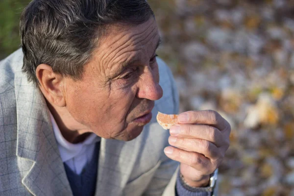 Hombre Mayor Comiendo Mandarina Aire Libre —  Fotos de Stock