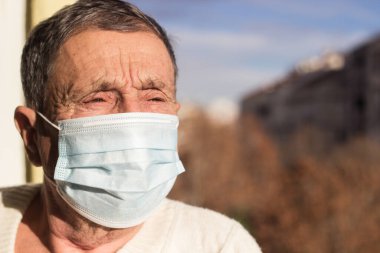 Koruyucu yüz maskesi takan yaşlı bir adamın portresi. Sağlık güvenliği kavramı