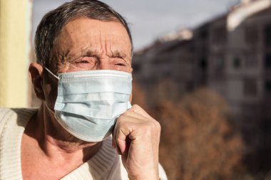 Koruyucu yüz maskesi takan yaşlı bir adamın portresi. Sağlık güvenliği kavramı