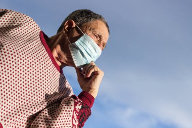Koruyucu yüz maskesi takan yaşlı bir adamın portresi. Sağlık güvenliği kavramı