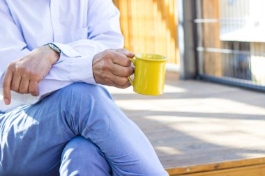 Son sınıf öğrencisi sabah kahvesini dışarıda içiyor. Hayal kurmak