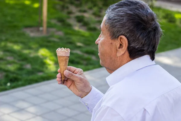 Modern and happy senior Man eating ice cream outdoor on a sunny day