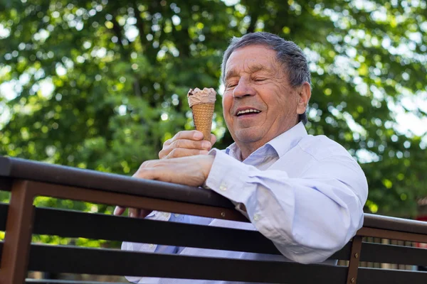 Modern and happy senior Man eating ice cream outdoor on a sunny day