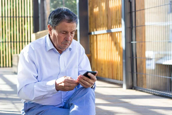 Senior man and his smartphone. Modern mature man have fun using smart phone outdoors