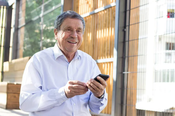 Senior man and his smartphone. Modern mature man have fun using smart phone outdoors