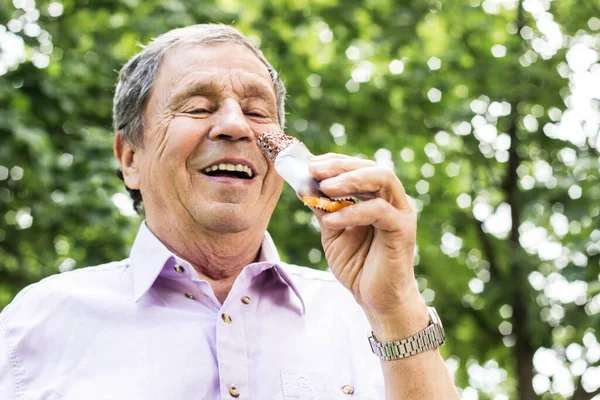 Senior man eating a protein bar, healthy lifestyle concepts, snack