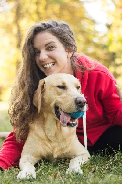 若いです笑顔女性とともに彼女の可愛いです犬で公共公園 — ストック写真