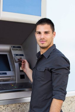 Yakışıklı genç adam kredi kartını ATM 'ye koymuş.