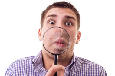 Büyüteçle şaşırmış adam, beyaz camda izole edilmiş.