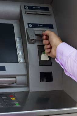 Kredi kartı olan bir iş adamı, ATM kullanıyor.