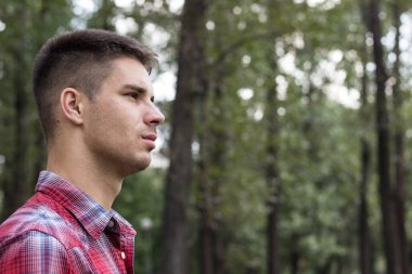 Parkta gülümseyen genç adam portresi