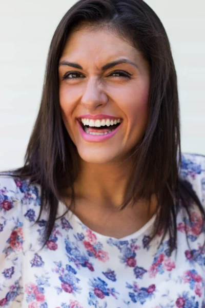 Young woman laughing, looking at camera