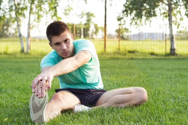 An attractive male stretching before his workout, outdoors