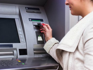 ATM 'de kredi kartından para çeken bir kadın.