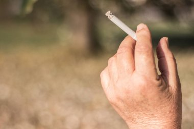 Kıdemli sigara içen kadın filtre ucu içiyor.