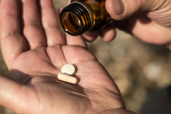 Photo of a senior woman hand holding a pills