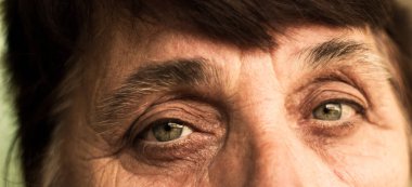 Düşünceli, yaşlı bir kadının portresi. Kameraya bakıyor, vesikalık.