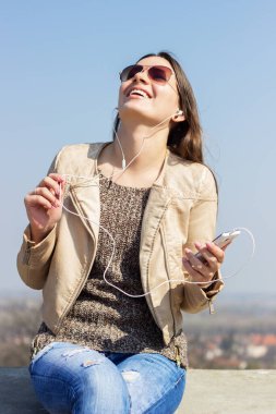 Güzel gülümseyen kız müzikten hoşlanıyor.