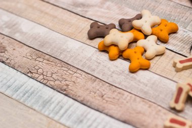 Evcil hayvan maması, köpekler için atıştırmalıklar. Ahşap arka planda köpek renkli bisküviler.