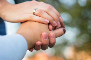 Sisters hold hands, nature bokeh background