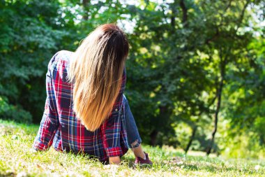 Genç bir kadın doğa manzarasının tadını çıkarıyor. Arka görünüm