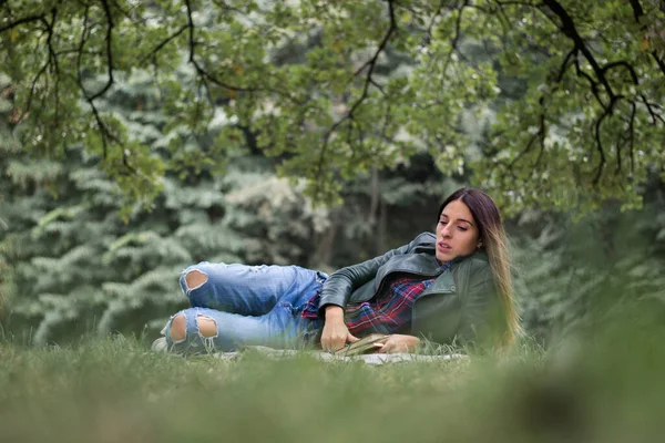 Mulher Lendo Livro Enquanto Deitado Grama Livre Parque — Fotografia de Stock