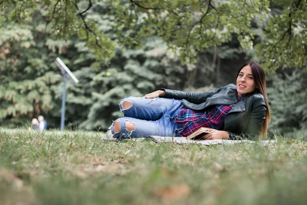Mulher Lendo Livro Enquanto Deitado Grama Livre Parque — Fotografia de Stock