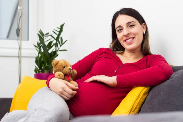 Pregnant Woman Holding Teddy Bear Resting Home — стоковое фото