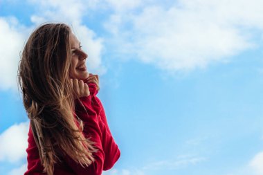 Beautiful smiling young girl, against a sky background
